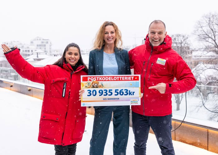 SOS-barnebyers generalsekretær Sissel Aarak sammen med Postkodelotteriets ambassadører Tom Stiansen og Jorun Stiansen. Jorunn og Tom har rød jakke med Postkoelotteriets logo. Sissel har blå dress og lyseblå genser. Foto Yina Chan/PKL