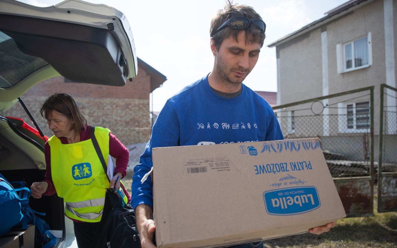 Regional nødhjelpsrådgiver Julian Erjautz og nødhjelpskoordinator Dagne Hordvei leverer utstyr til internt fordrevne i Lviv, vest i Ukraina. Dagne har selvlysende vest med SOS-barnebyers logo, Julian har blå genser med SOS-barnebyers logo. Foto: SOS-barnebyer