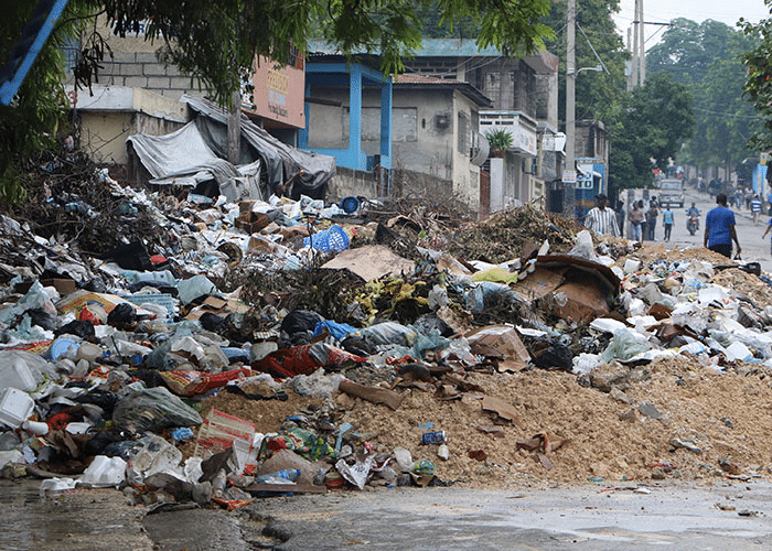 Hus ødelagt, murpuss og stein ligger utover gata. Fra Les Cayes, Haiti. Foto: Peter Anis