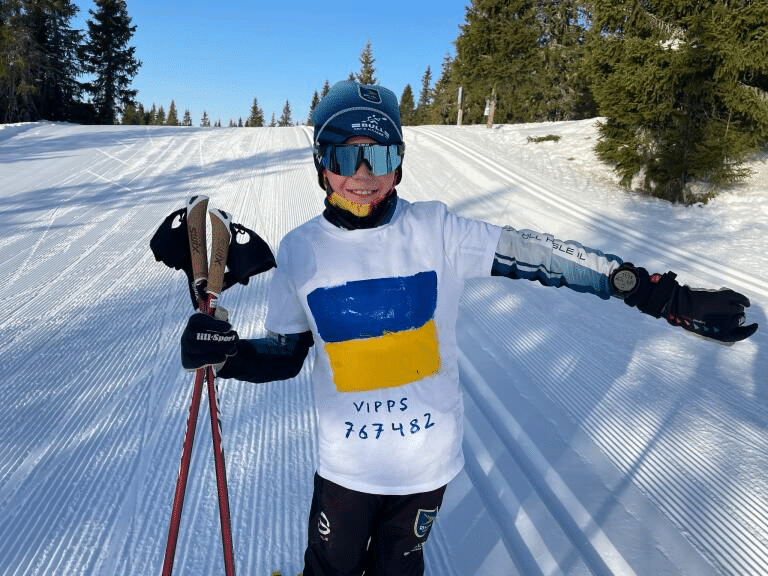 Magnus Semb (10 år) i løypene på Sjusjøen. 
han har hvit t-skjorte utenpå skidressen der han har malt de ukrainske fargene og vippsnr. 767482. Foto: Privat