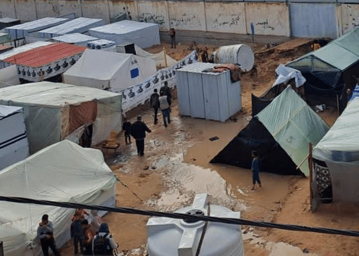 Magne telt utenfor SOS-barnebyen i Rafah. Bakken er oversvømt av brunt vann. Foto SOS-barnebyer