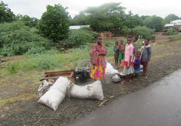 Malawi rammet av flom: En gruppe barn står ved kanten av flomvannet sammen med noen eiendeler fra husene deres. Foto: SOS-barnebyer