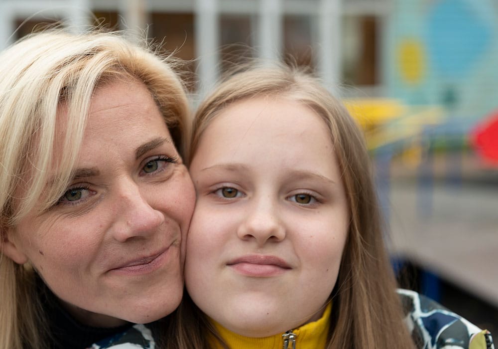 Ukraina: Moren, med lyst halvlangt hår, gir Sofiya, som har blond langt hår, en klem. Foto: Katerina Ilievska