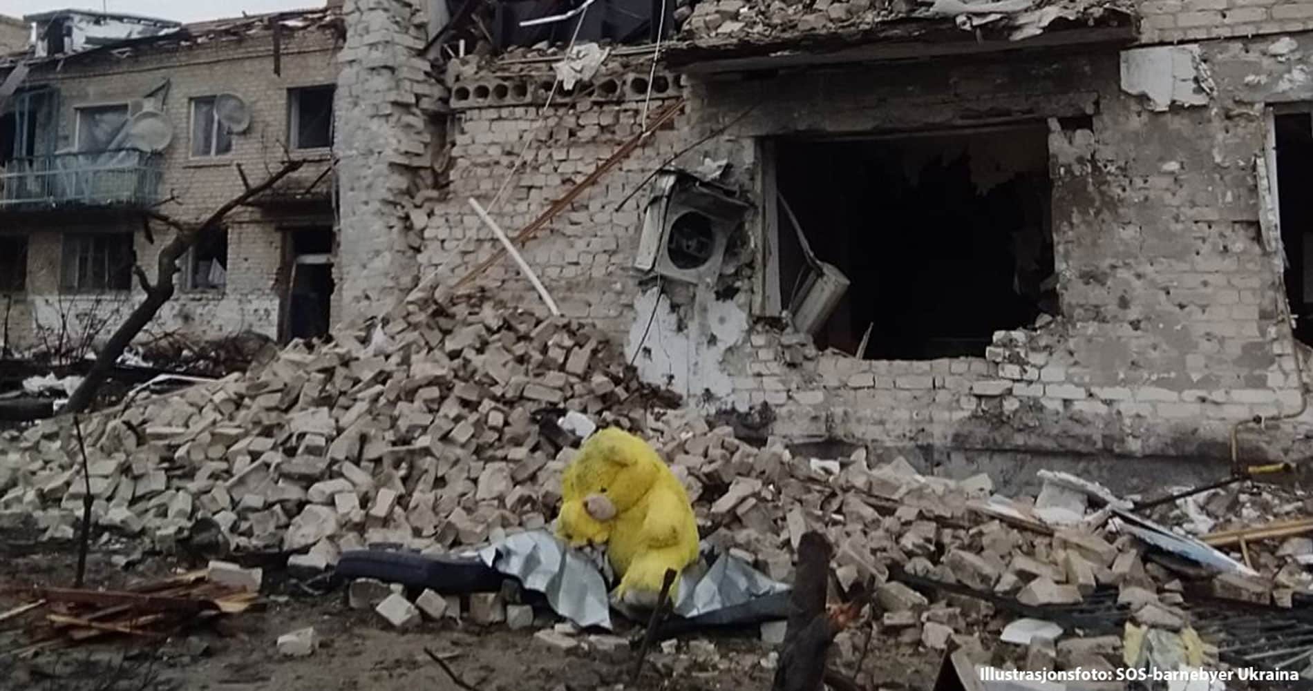 Krigen har ødelagt mye begyggelse. Her er det et hus i ruiner. I forgrunnen ligger en kosebamse. Illustrasjonsfoto SOS-barnebyer Ukraina