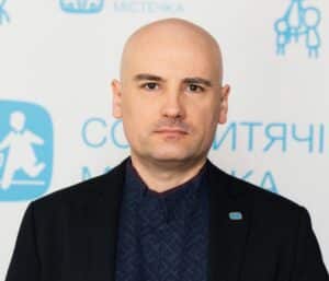 Serhii Lukashov, leder i SOS-barnebyer Ukraina. Han er glattbarbert på hodet og har svart skjorte og svart dressjakke. Foto SOS-barnebyer Ukraina